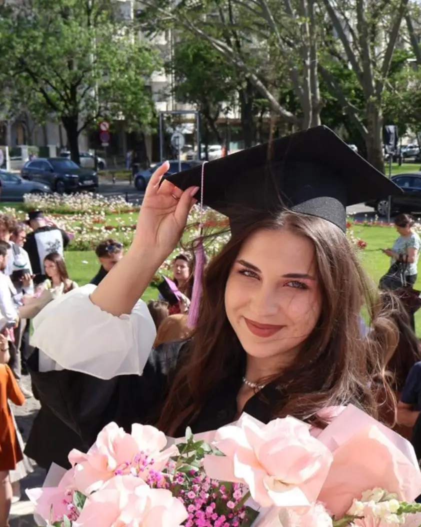 Nora Lăzărescu ridicând toca în ziua absolvirii